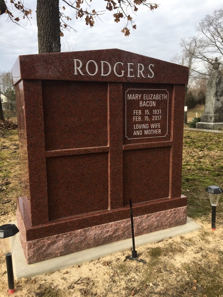 Granite columbarium with polished niche fronts, installed in a cemetery